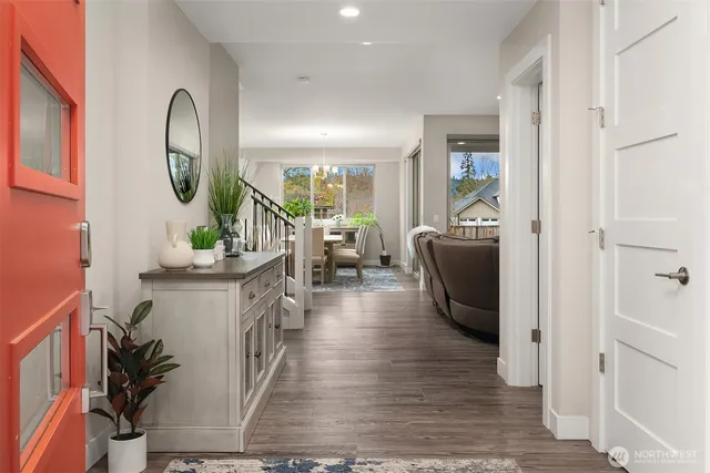 a living room with furniture a mirror and a wooden floor