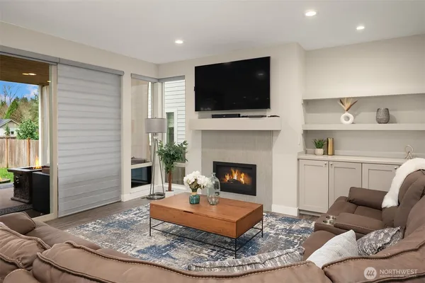 a living room with furniture a flat screen tv and a fireplace