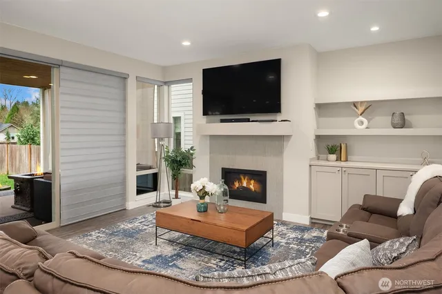 a living room with furniture a flat screen tv and a fireplace