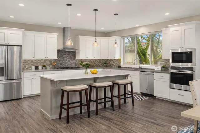 a kitchen with a table chairs microwave and cabinets