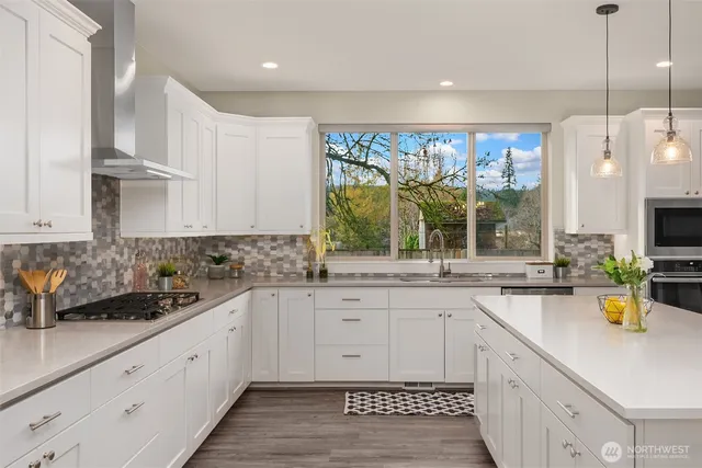 a kitchen with a sink a counter top space cabinets and stainless steel appliances