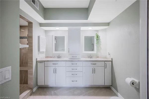 a spacious bathroom with a granite countertop sink a mirror and a