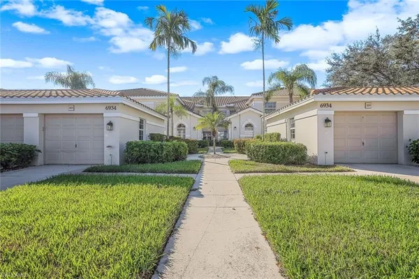 a front view of a house with a garden and yard