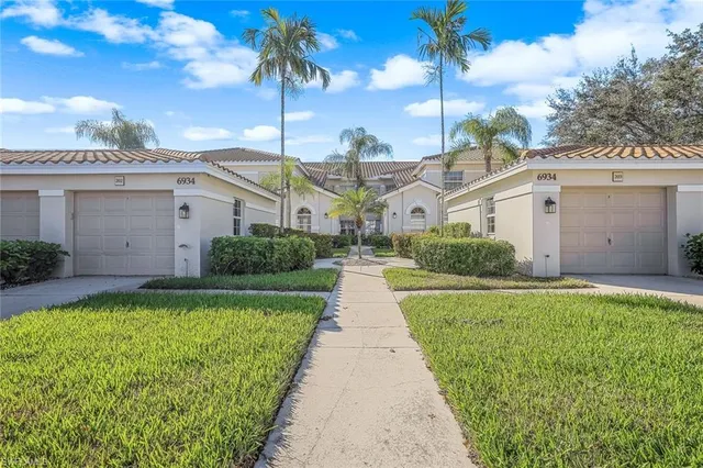 a front view of a house with a garden and yard