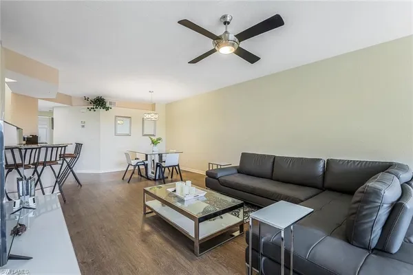a living room with furniture a view of bedroom and a couch