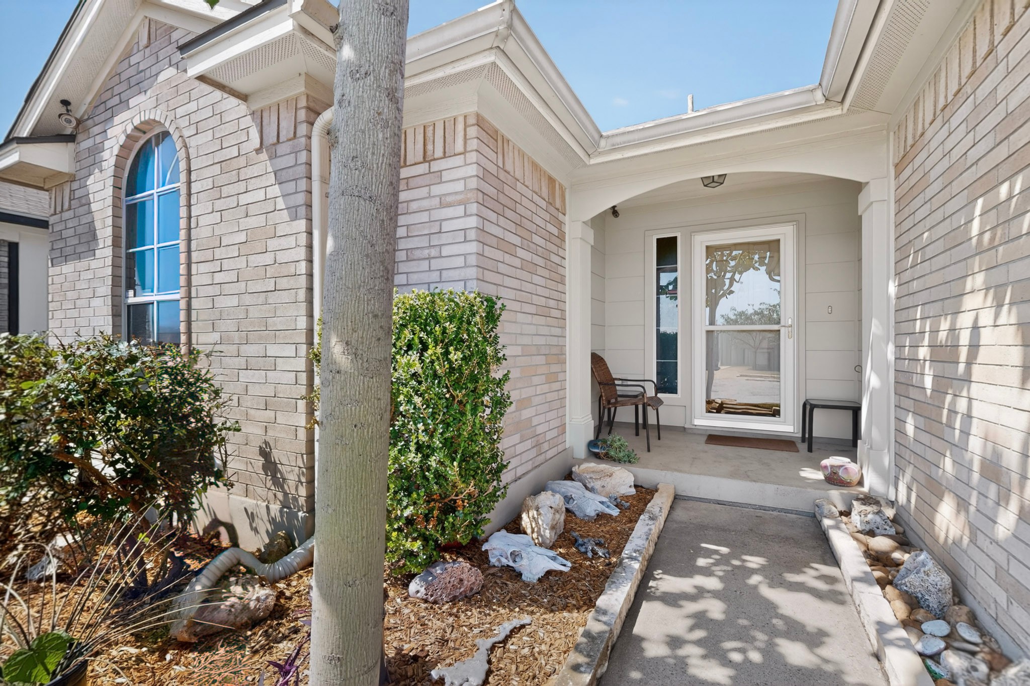 15104 Mimebark Way Austin, TX 78724 - Photo 6 of 38 Inviting entryway featuring a covered porch, light-colored brick exterior, and an arched window