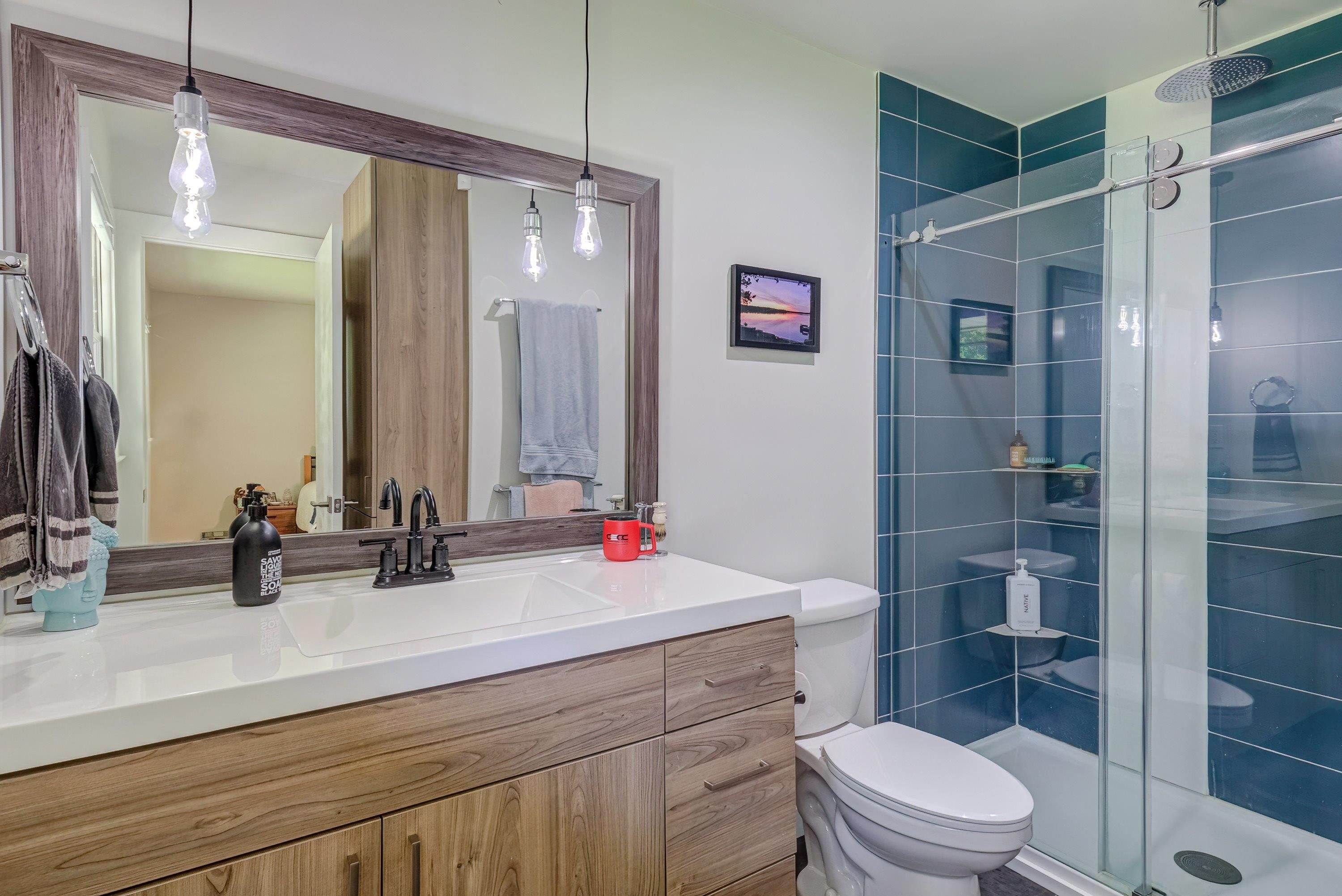 2405 Brenda Drive Raleigh, NC 27610 - Photo 23 of 27 a bathroom with a sink a toilet a shower and a mirror