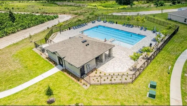 a view of a swimming pool with a yard and plants