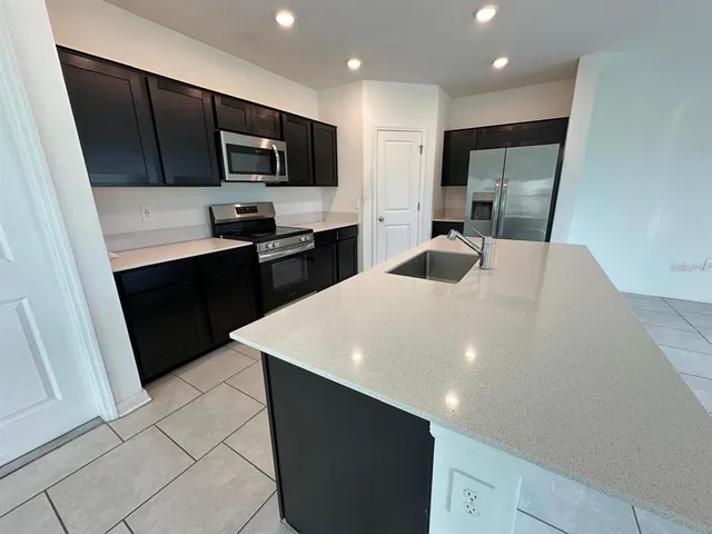 a kitchen with stainless steel appliances a refrigerator sink microwave and stove