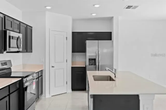a kitchen with stainless steel appliances a refrigerator and a stove