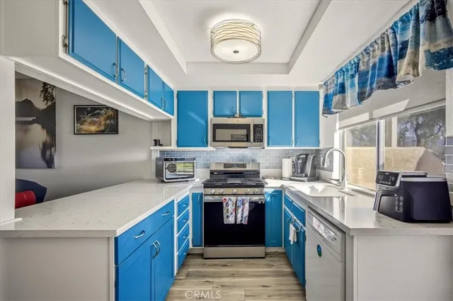 a kitchen with stainless steel appliances granite countertop a stove a sink and a microwave