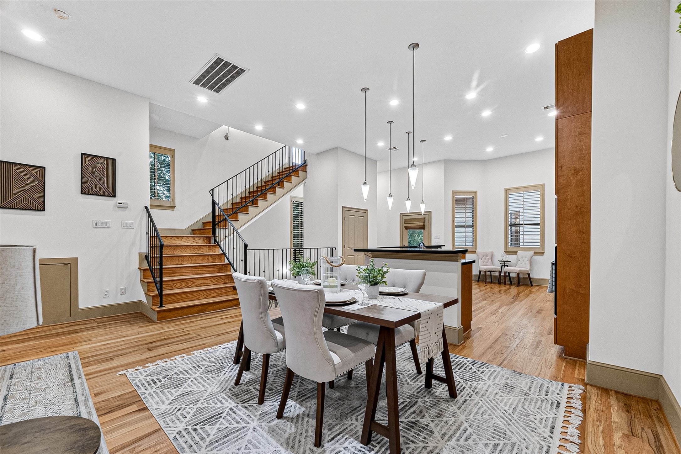 2034 Colquitt Street, Unit A Houston, TX 77098 - Photo 22 of 41 This classic, open-concept living space features a dining area with elegant pendant lighting and hardwood floors. The room is bright and inviting, with a staircase leading to the 3rd level.