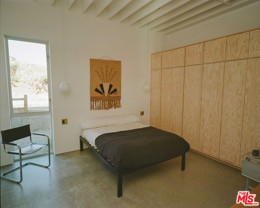 7825 Conejo Avenue Joshua Tree, CA 92252 - Photo 14 of 34 a bedroom with a bed and a table