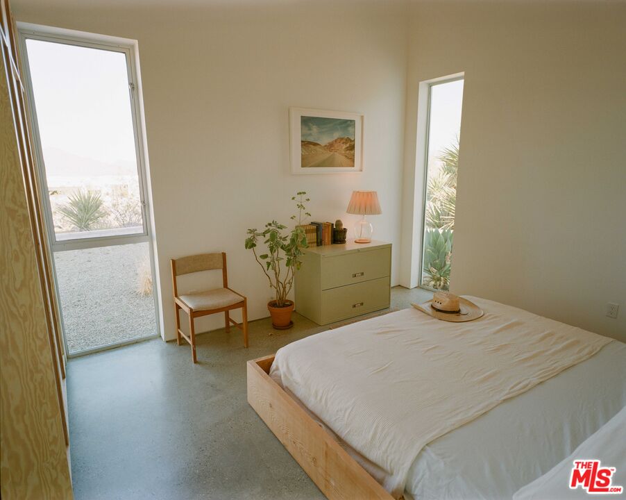 7825 Conejo Avenue Joshua Tree, CA 92252 - Photo 30 of 34 a bedroom with a bed and a window