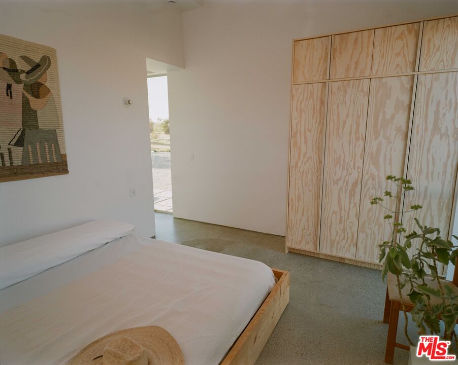 7825 Conejo Avenue Joshua Tree, CA 92252 - Photo 31 of 34 a bedroom with a bed and a potted plant
