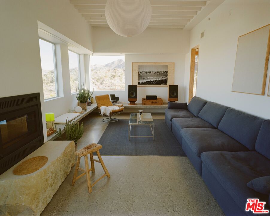 7825 Conejo Avenue Joshua Tree, CA 92252 - Photo 4 of 34 a living room with furniture fireplace and a large window