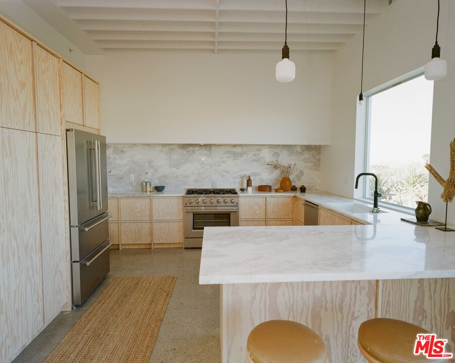 7825 Conejo Avenue Joshua Tree, CA 92252 - Photo 10 of 34 a kitchen with stainless steel appliances granite countertop a sink a stove and refrigerator