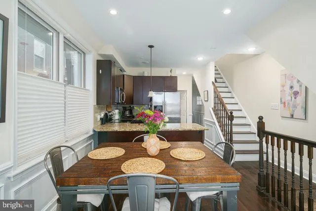 a view of a dining room with furniture a kitchen and wooden floor