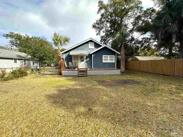 a front view of a house with a garden and yard