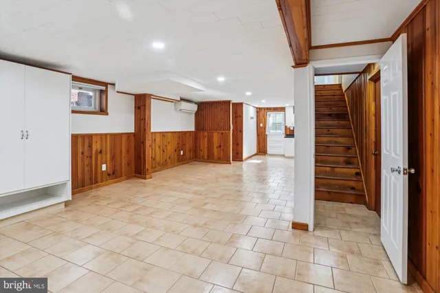 a view of a hallway with stairs and a cabinet door
