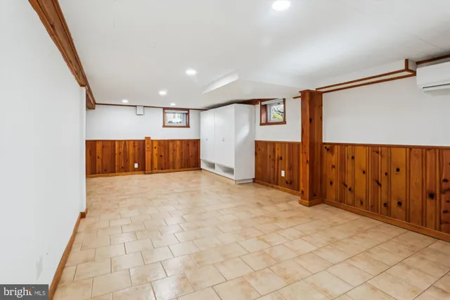 a view of a hallway with wooden floor and a refrigerator