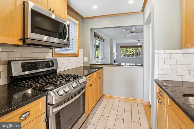 a kitchen with stainless steel appliances a stove a microwave and a sink