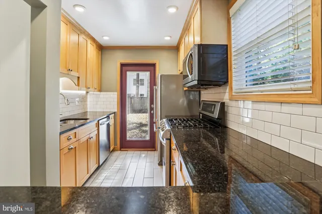a kitchen with stainless steel appliances granite countertop a stove and a refrigerator