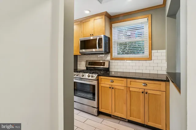 a kitchen with stainless steel appliances a stove microwave and refrigerator