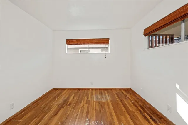 a view of a room with wooden floor and a ceiling fan