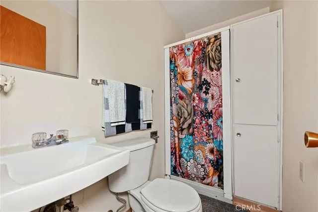 a bathroom with a granite countertop sink mirror vanity and toilet