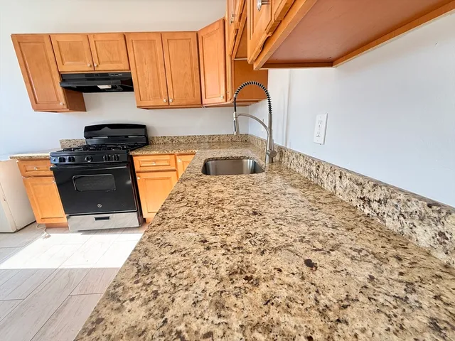 a kitchen with stainless steel appliances granite countertop a stove a sink and a microwave
