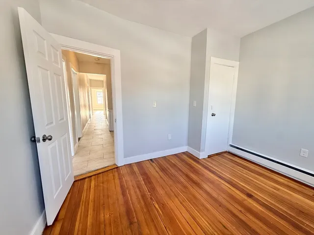 an empty room with wooden floor and a window