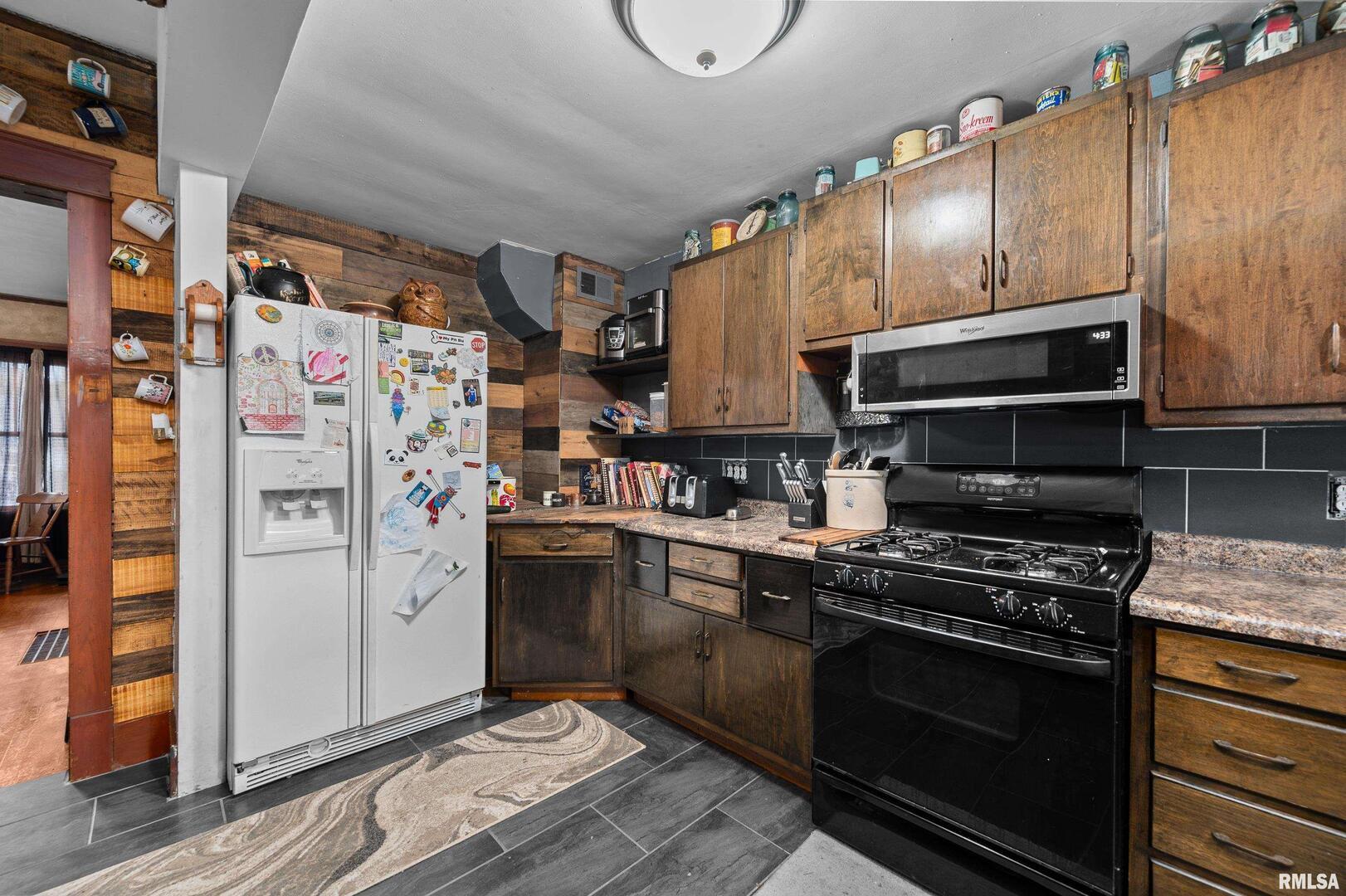 415 Southwest 4th Avenue Galva, IL 61434 - Photo 19 of 38 a kitchen with stainless steel appliances kitchen island granite countertop a stove and a refrigerator