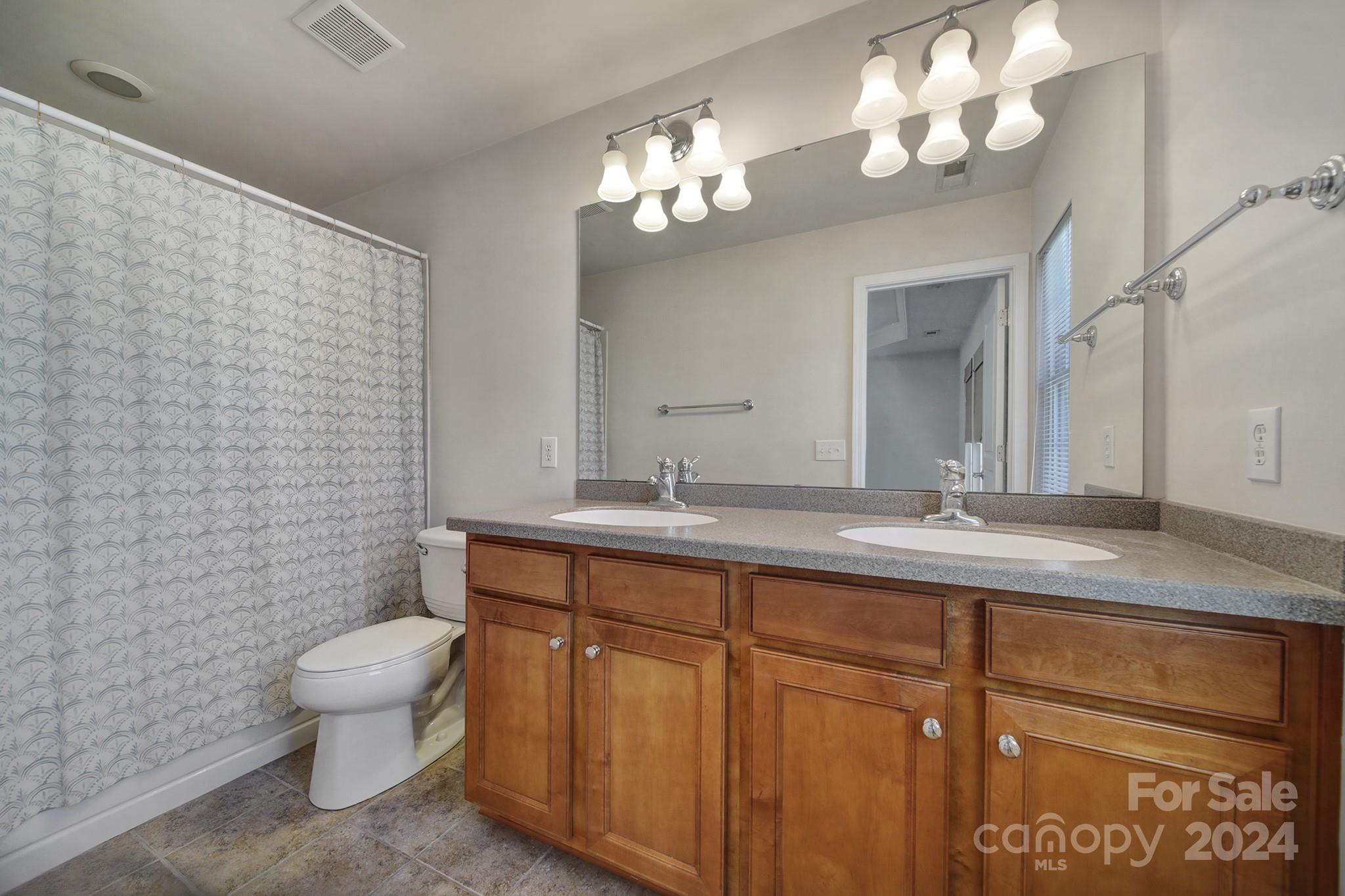 807 Granby Drive Fort Mill, SC 29708 - Photo 22 of 33 a bathroom with a granite countertop sink a toilet and a mirror