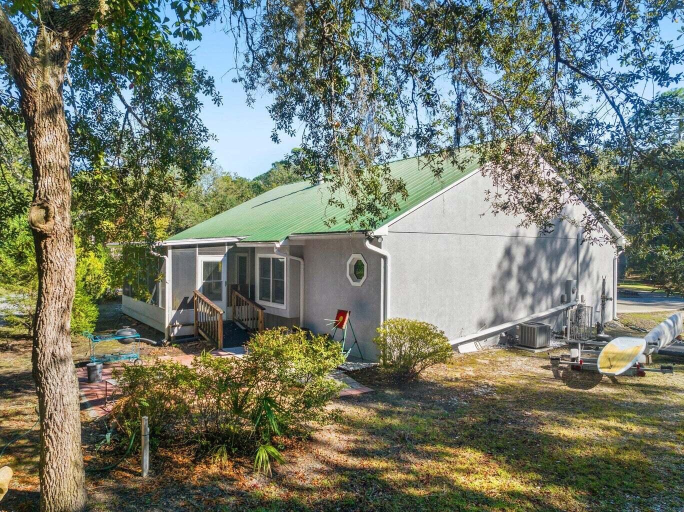 49 Wish Lane Santa Rosa Beach, FL 32459 - Photo 24 of 26 a backyard of a house with table and chairs under an umbrella