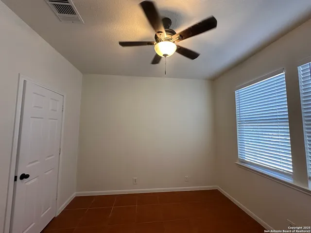 an empty room with a window and a fan