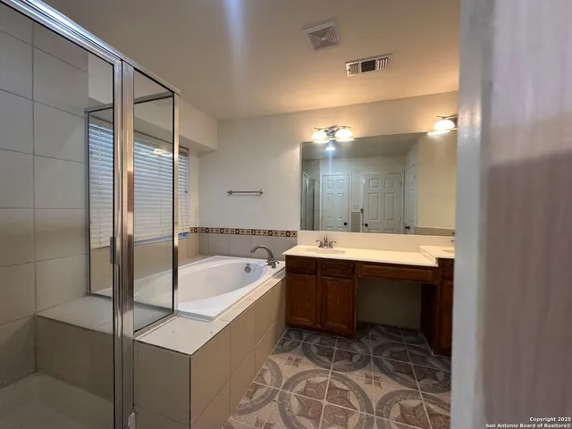 a bathroom with a tub sink and mirror