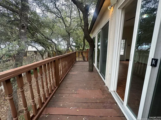 a balcony with wooden floor in front of house