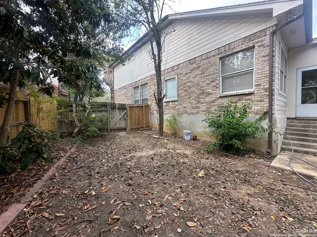 a view of a backyard with large trees