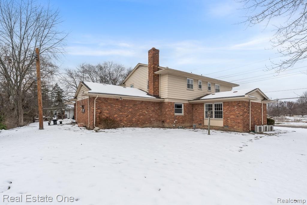 28777 West 11 Mile Road Farmington, MI 48336 - Photo 49 of 53 Snow covered rear of property with brick siding and a chimney