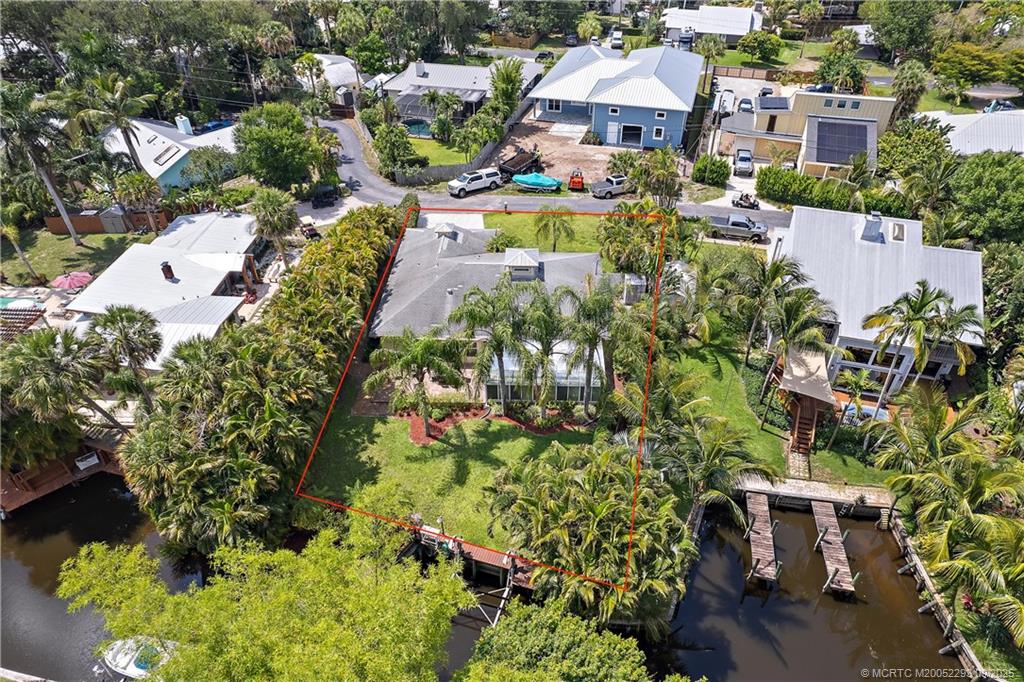 an aerial view of residential houses with outdoor space and trees all around