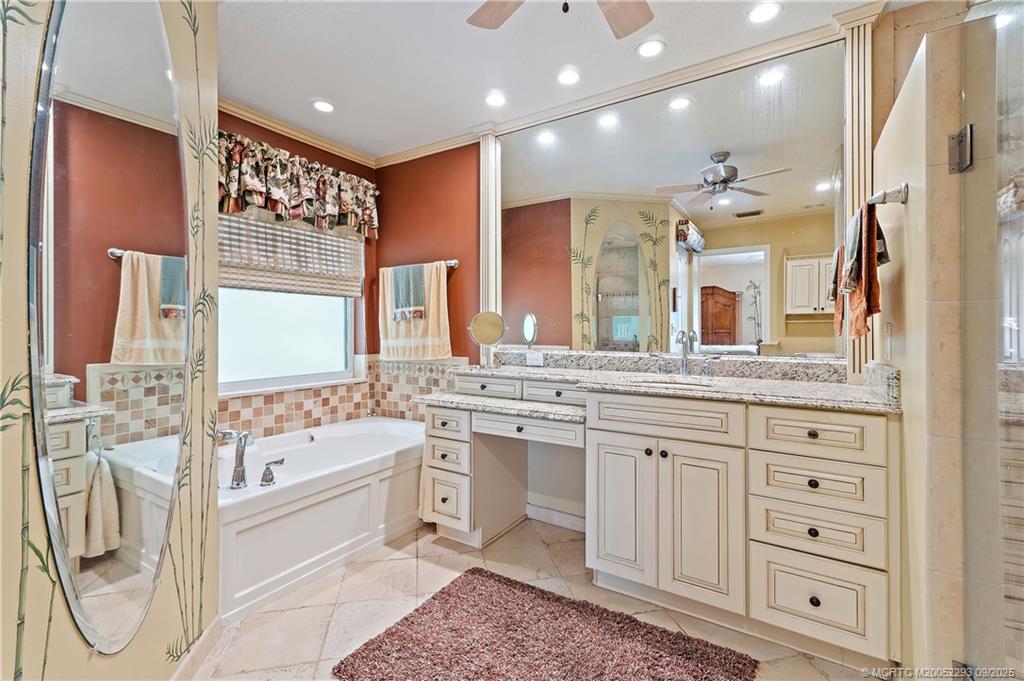 815 Southwest Rustic Circle Stuart, FL 34997 - Photo 12 of 20 a bathroom with a double vanity sink a mirror and a bathtub