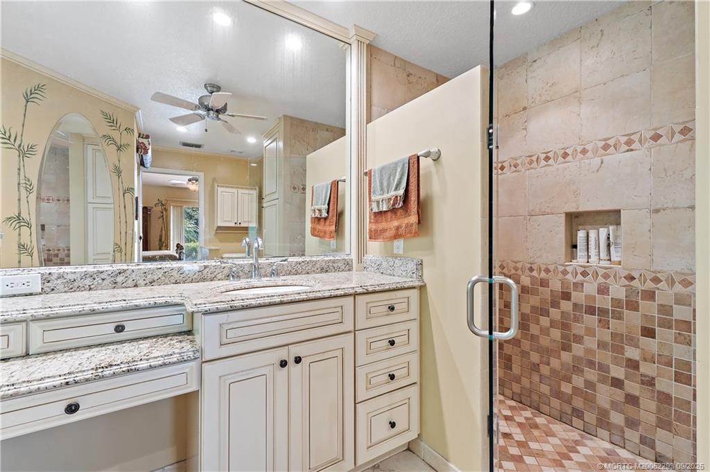 815 Southwest Rustic Circle Stuart, FL 34997 - Photo 13 of 20 a bathroom with a granite countertop sink a mirror and a shower