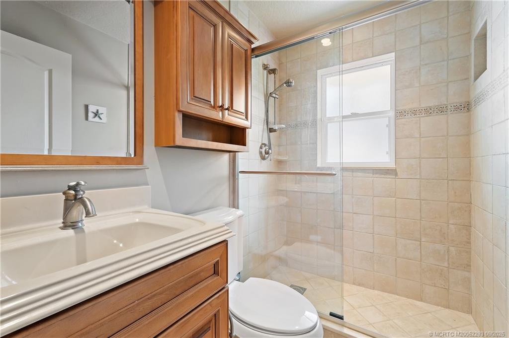 815 Southwest Rustic Circle Stuart, FL 34997 - Photo 14 of 20 a bathroom with a sink a toilet and shower