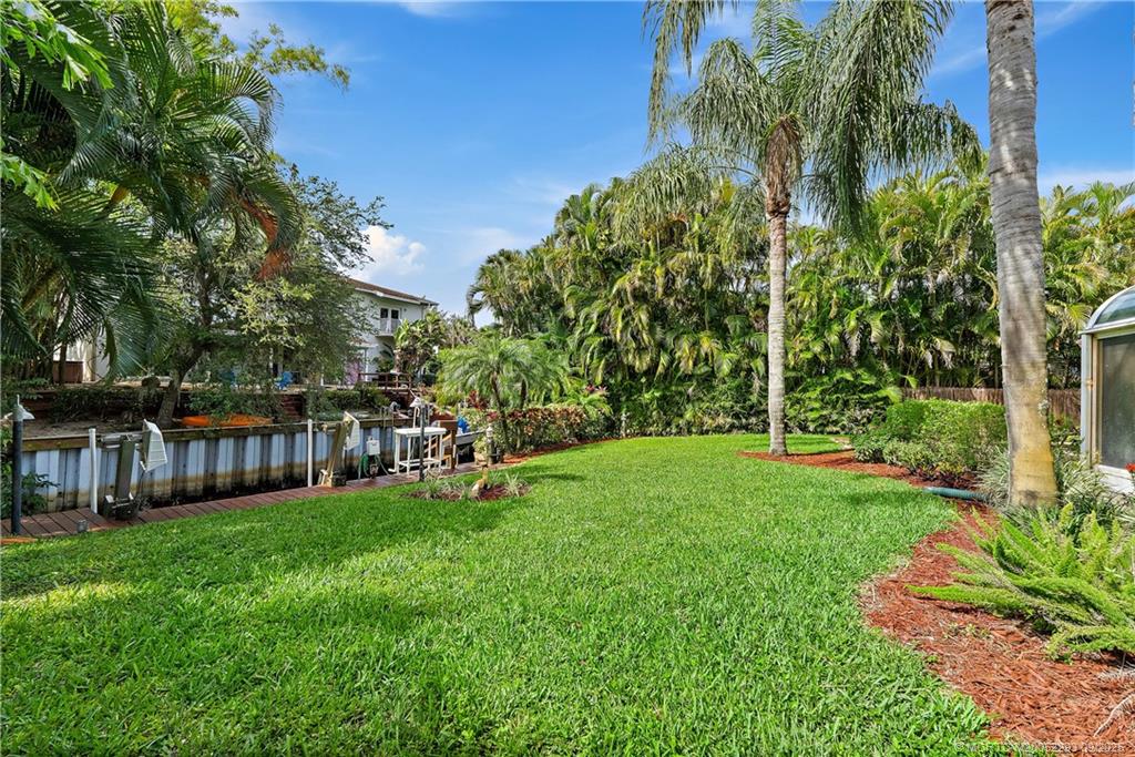 815 Southwest Rustic Circle Stuart, FL 34997 - Photo 15 of 20 a view of a yard with plants and large trees