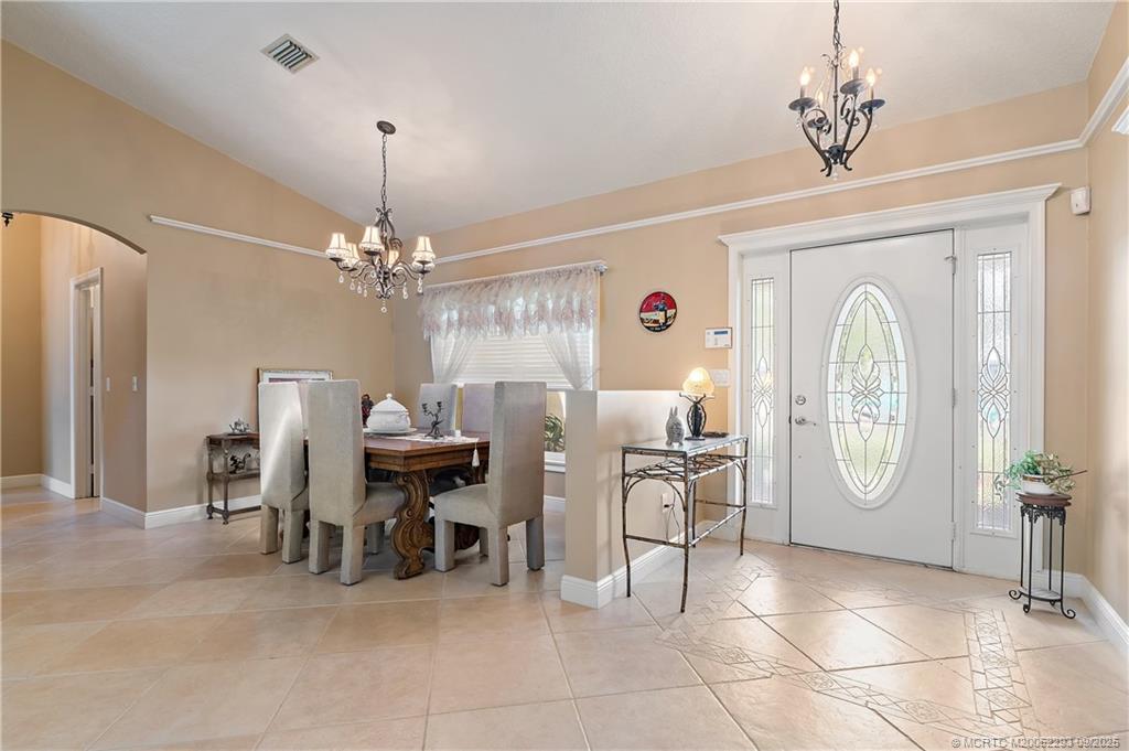 815 Southwest Rustic Circle Stuart, FL 34997 - Photo 5 of 20 a view of a dining room with furniture chandelier and wooden floor