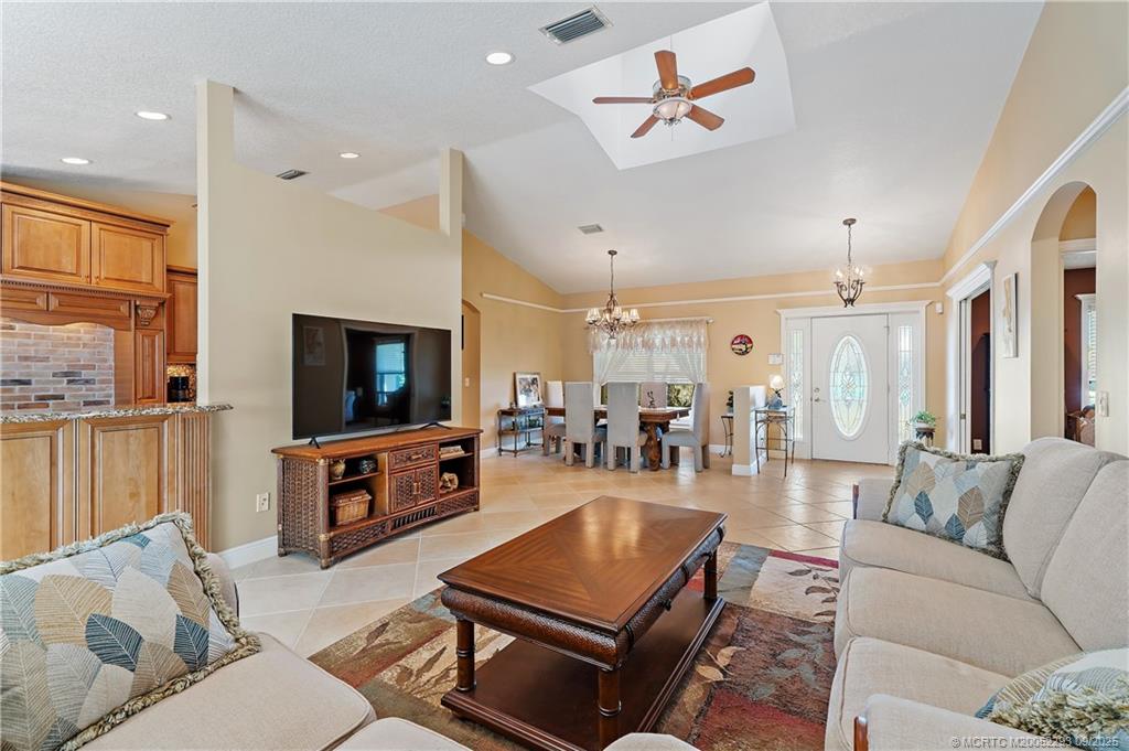 815 Southwest Rustic Circle Stuart, FL 34997 - Photo 6 of 20 a living room with furniture a flat screen tv and kitchen view