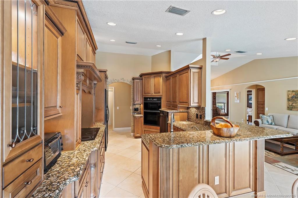 815 Southwest Rustic Circle Stuart, FL 34997 - Photo 8 of 20 a kitchen with stainless steel appliances granite countertop a refrigerator and a sink