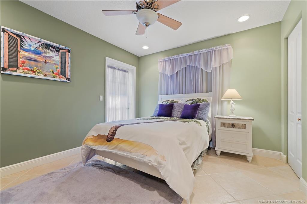 815 Southwest Rustic Circle Stuart, FL 34997 - Photo 10 of 20 a bedroom with a bed and a chandelier