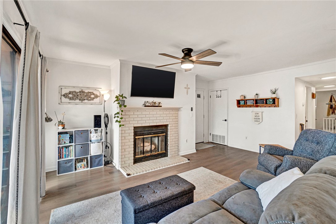 104 Captains Way Anderson, SC 29625 - Photo 32 of 47 This inviting living space features hardwood flooring and a classic brick fireplace, creating a cozy atmosphere.